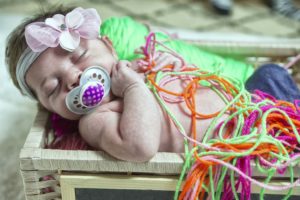 baby in basket with yarn