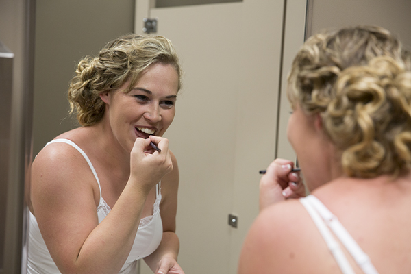 bride applies makeup