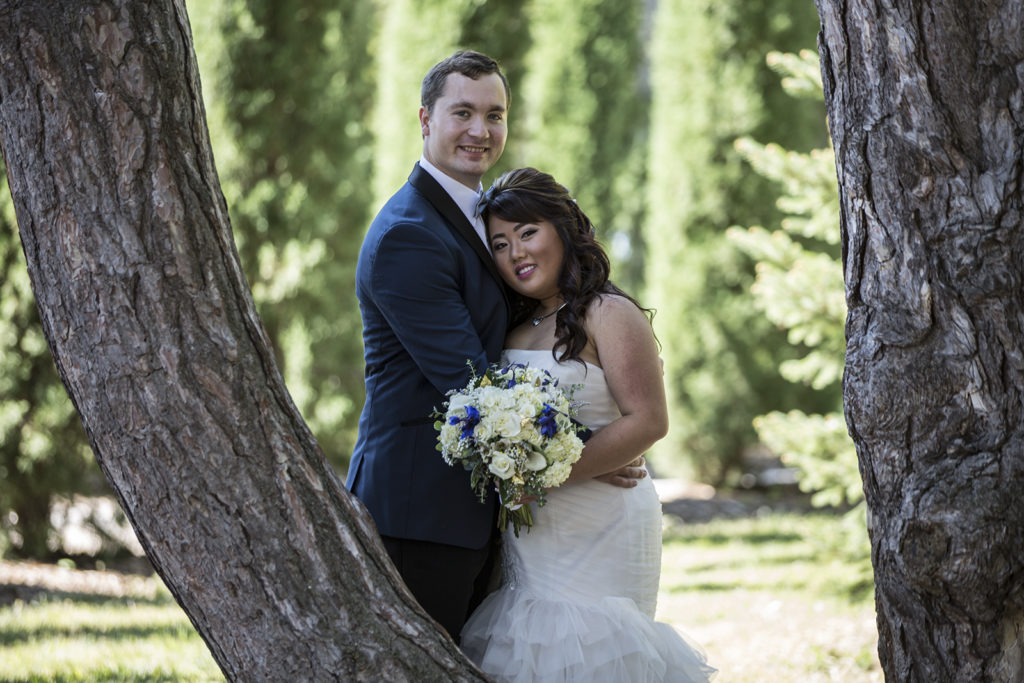Bride and groom between tree branches