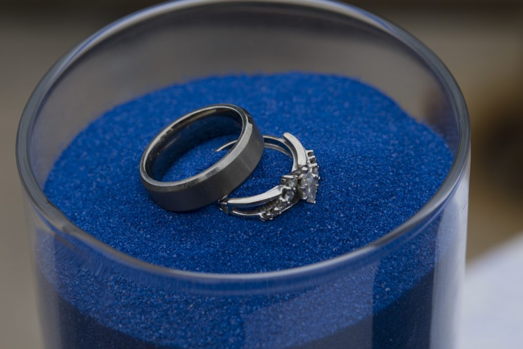 rings in container of blue sand
