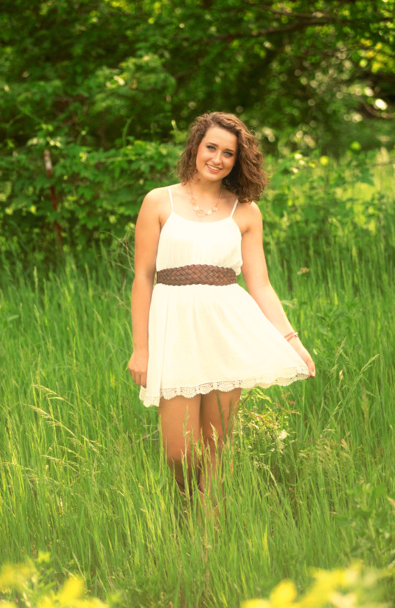 Senior stands in tall grass