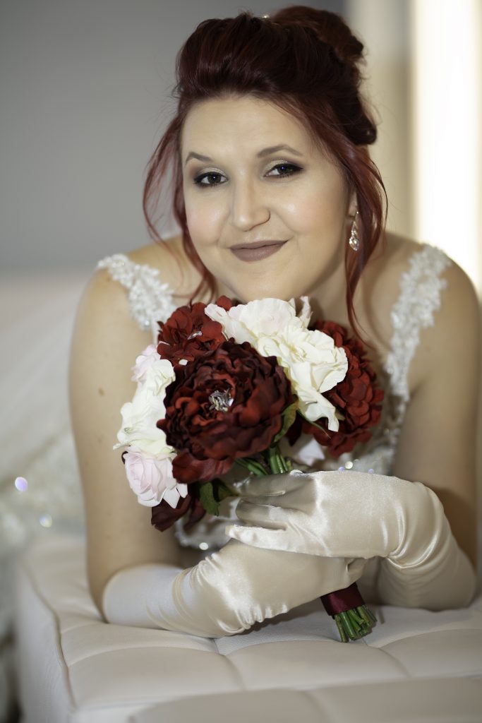 bride lies down, holds flowers