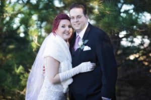 Portrait of bride and groom in front of a spruce tree