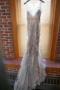 wedding dress hangs in window
