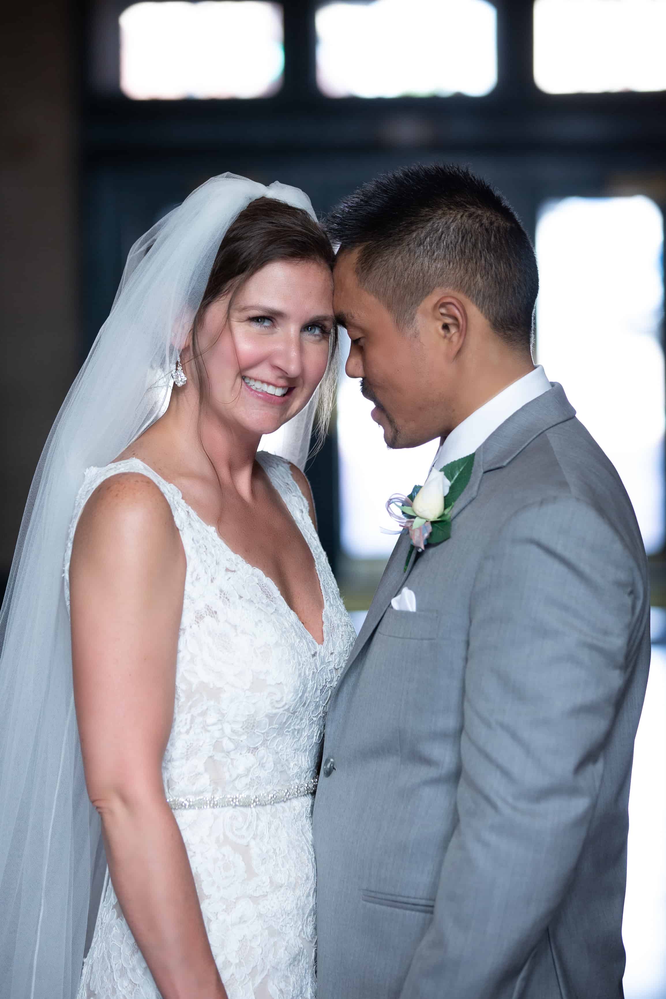 bride looks at camera, groom looks at bride