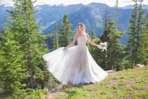 bride stands atop a mountain