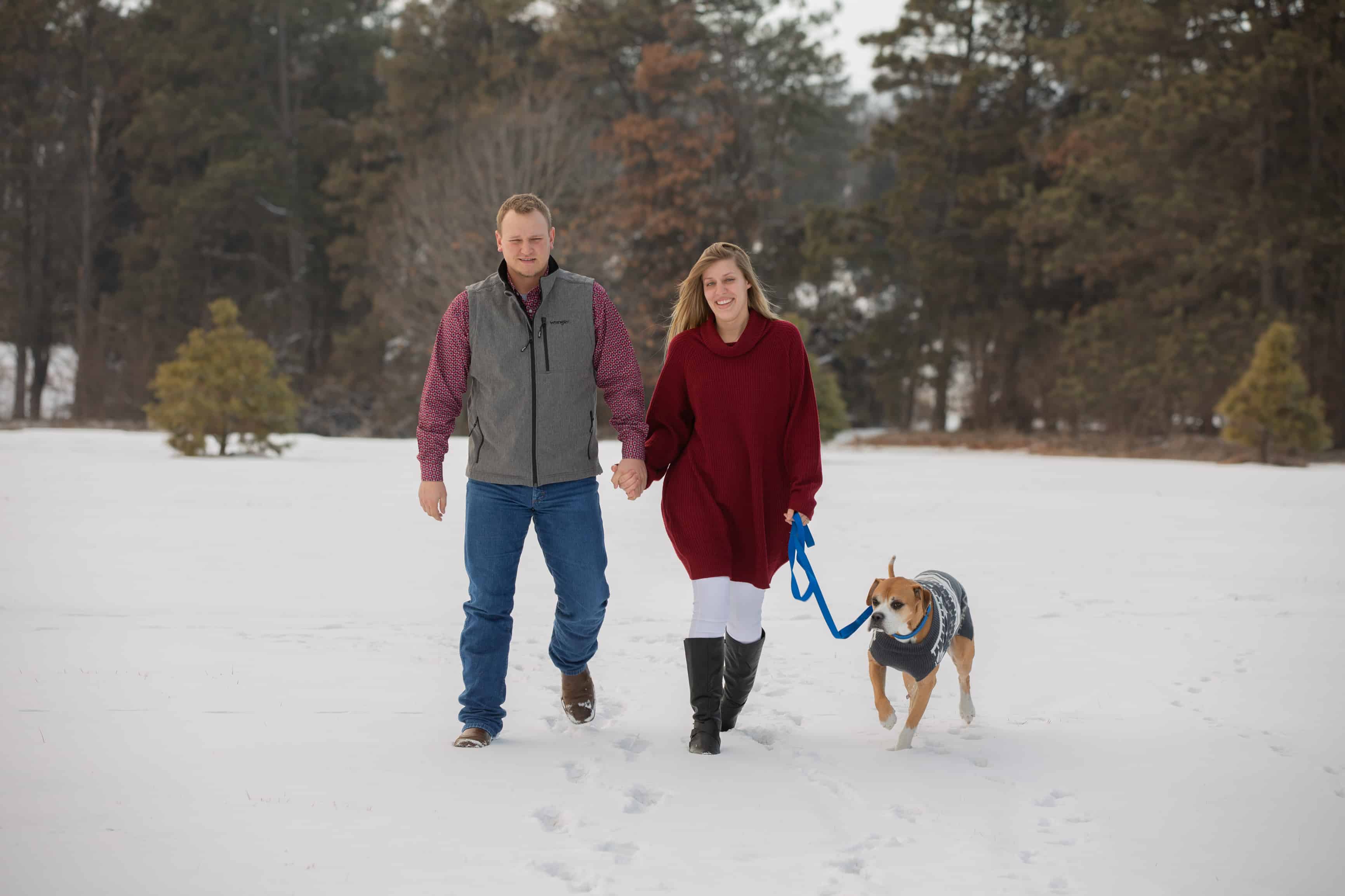 couple walk their dog in snow