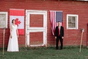 Couple stands by USA and Canadian flags