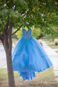 blue quinceanera dress hangs from tree