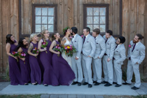 wedding party looks at bride and groom kissing