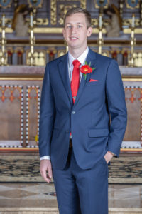 groom standing in front of church