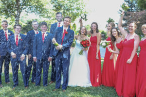 Groom opens champagne with wedding party watching