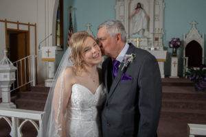father kisses bride