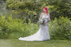 bride stands in front of pond