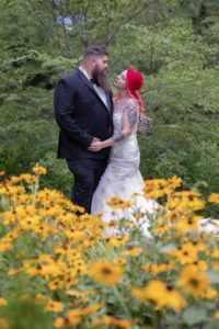 bride and groom behind yellow flowers