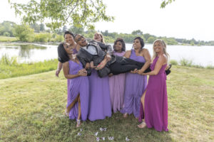 bridesmaids hold groom