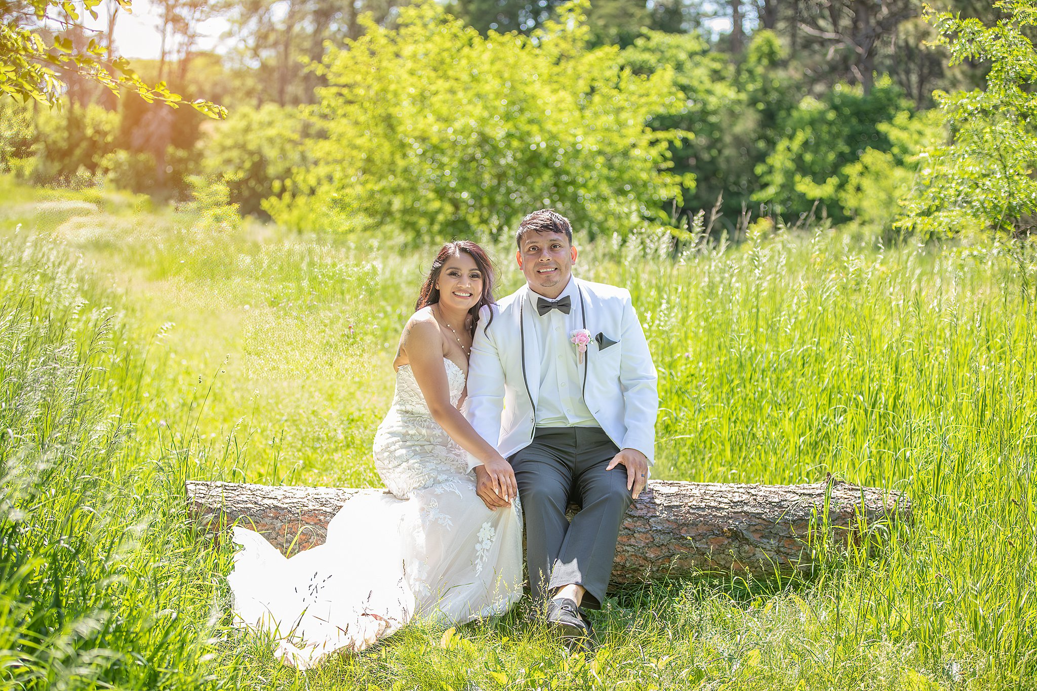 bride and groom sitting on a log Lilac Hill Nebraska