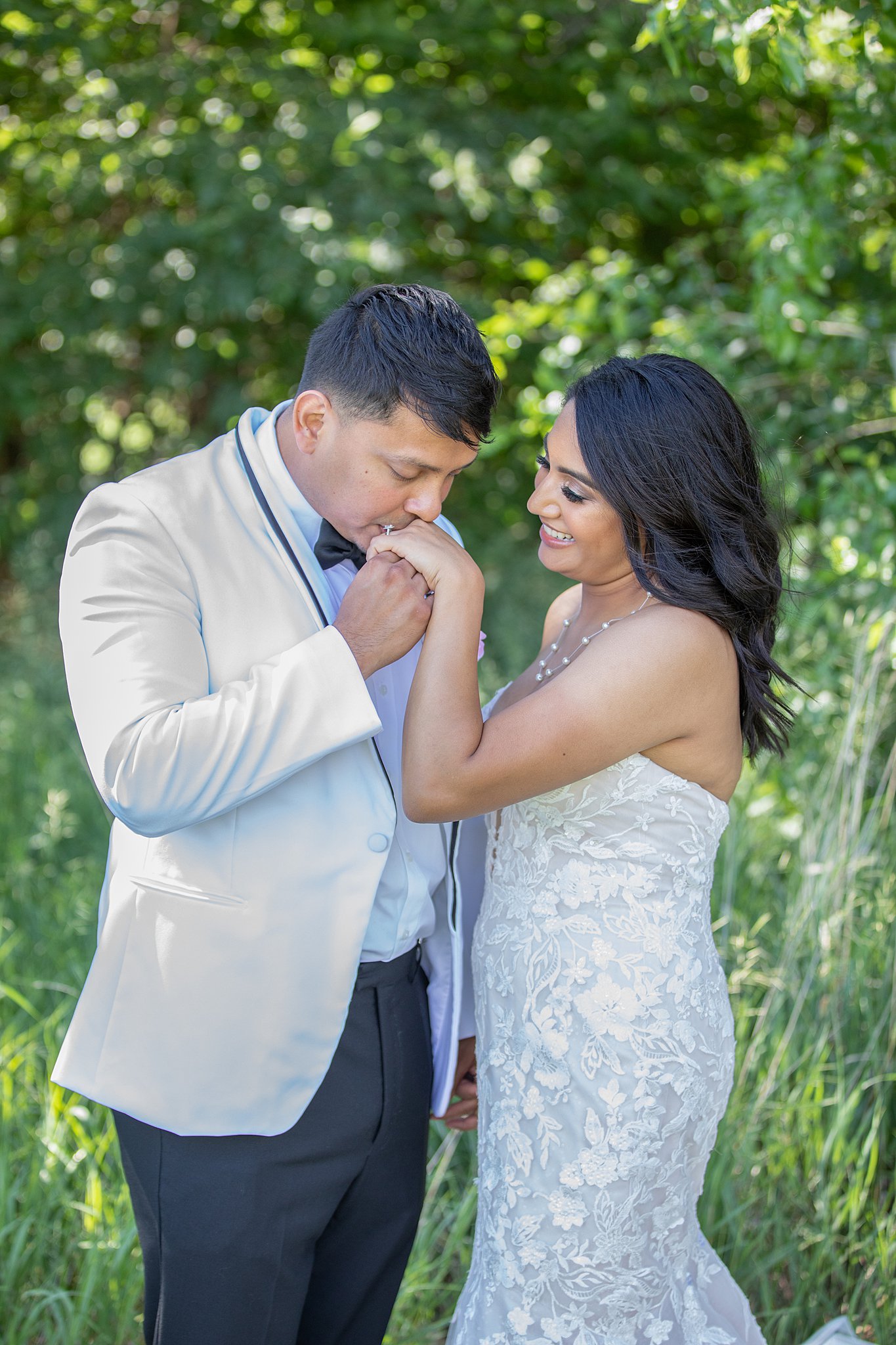 groom kissing his bride on the hand Lilac Hill Nebraska