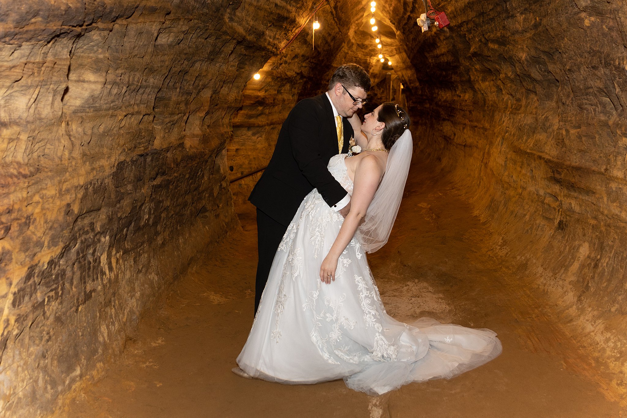 Groom dips his wife in a cavern path