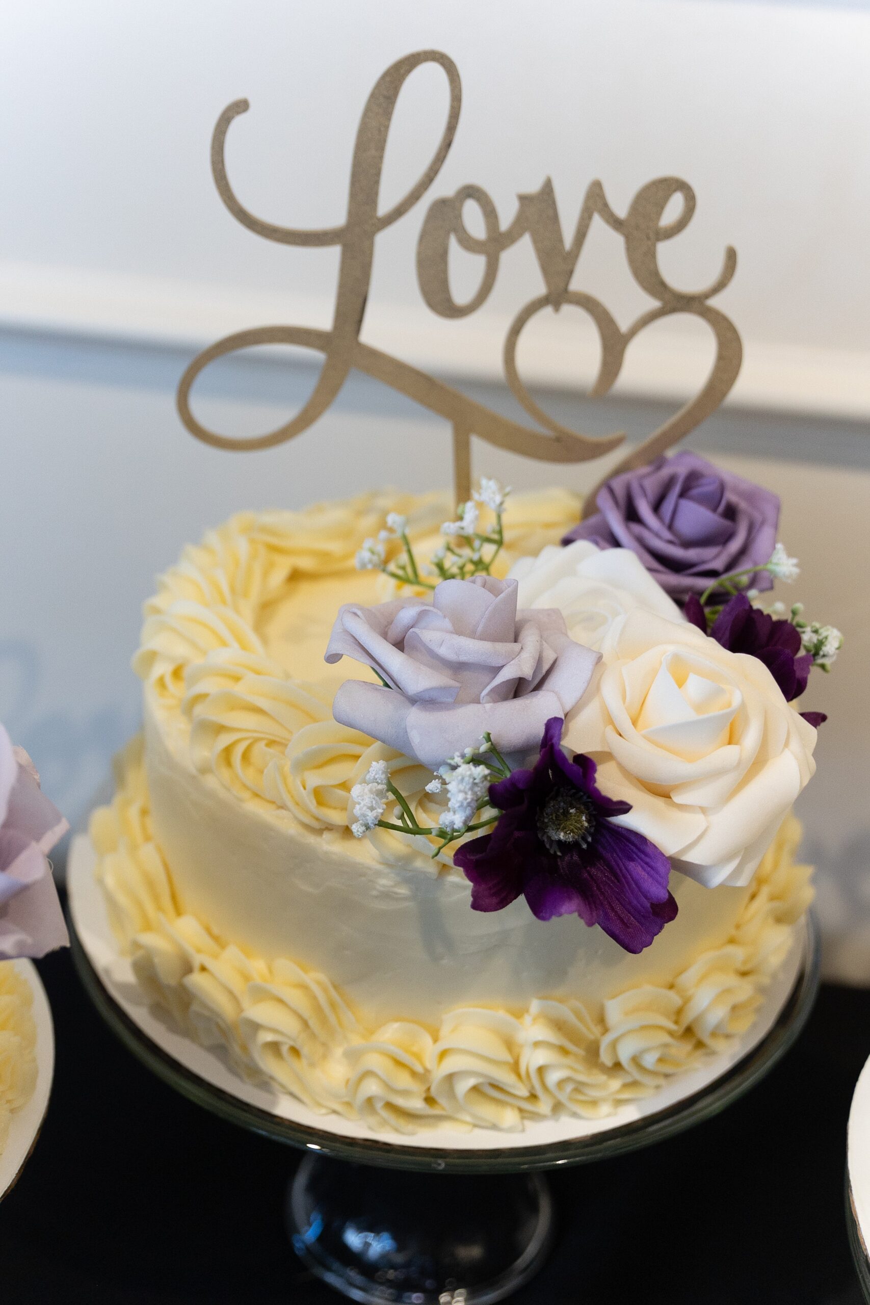 Details of a yellow wedding cake with a large floral decoration