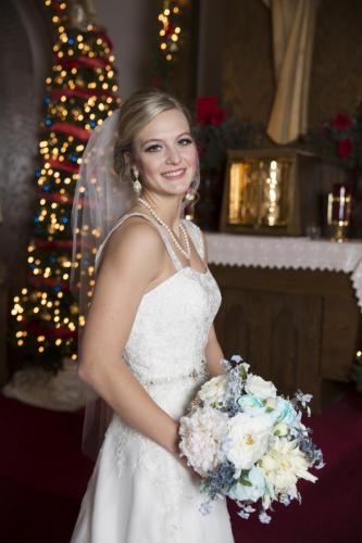 Wedding portrait of bride in front of Christmas lights.