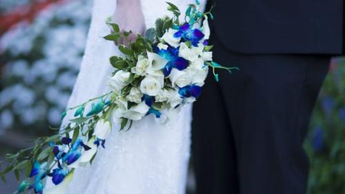 Bride holds blue and white wedding bouquet