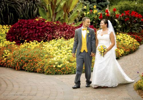 Bride and groom walk with flowers behind them